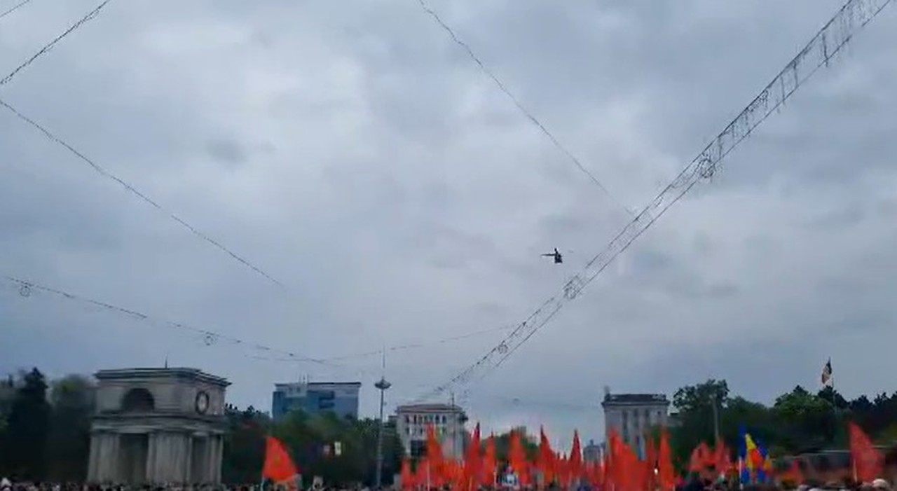 Вертолет с флагом ЕС над ПВНС, где собрались участники марша в честь Дня Победы