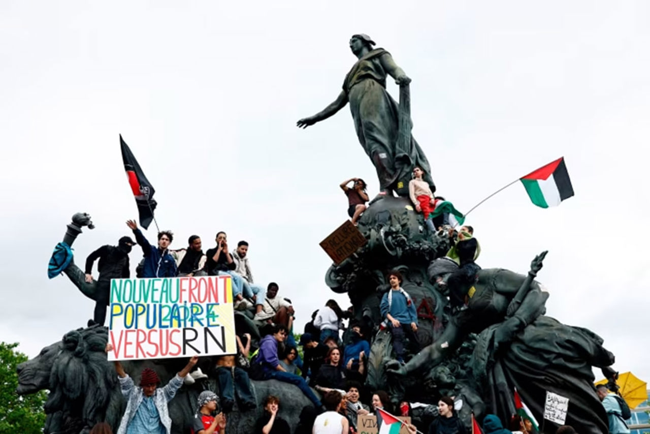 AFP/Getty Images // Protesters against the far-right climbing the Triumph of the Republic statue in Paris on Saturday