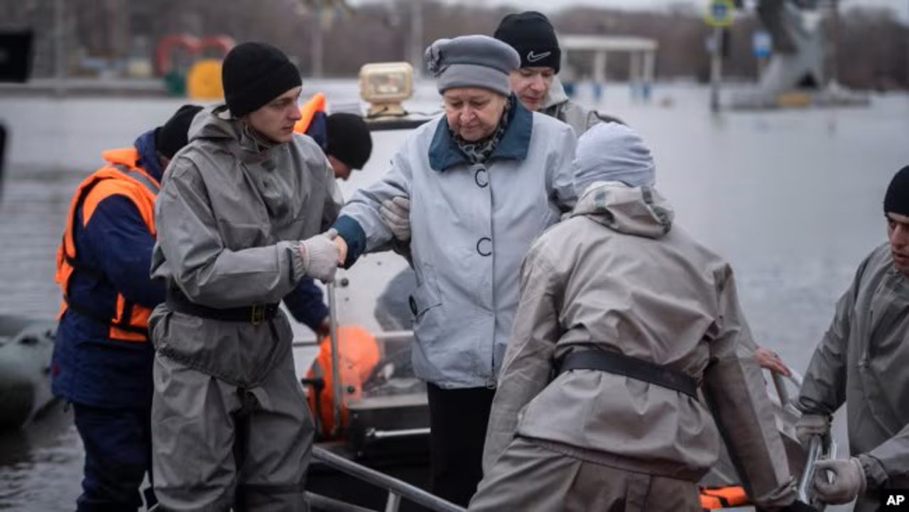 AP / Lucrătorii de urgență ajută o femeie să coboare de pe o barcă în timpul evacuării localnicilor, Orsk, Rusia, 8 aprilie 2024